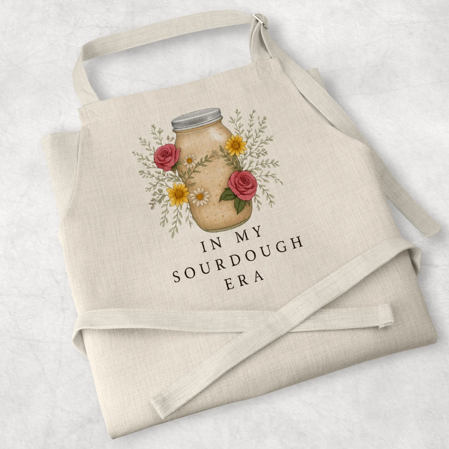 White cotton cooking apron with 'Sourdough Lover' design, perfect for baking enthusiasts and thoughtful mum gifts