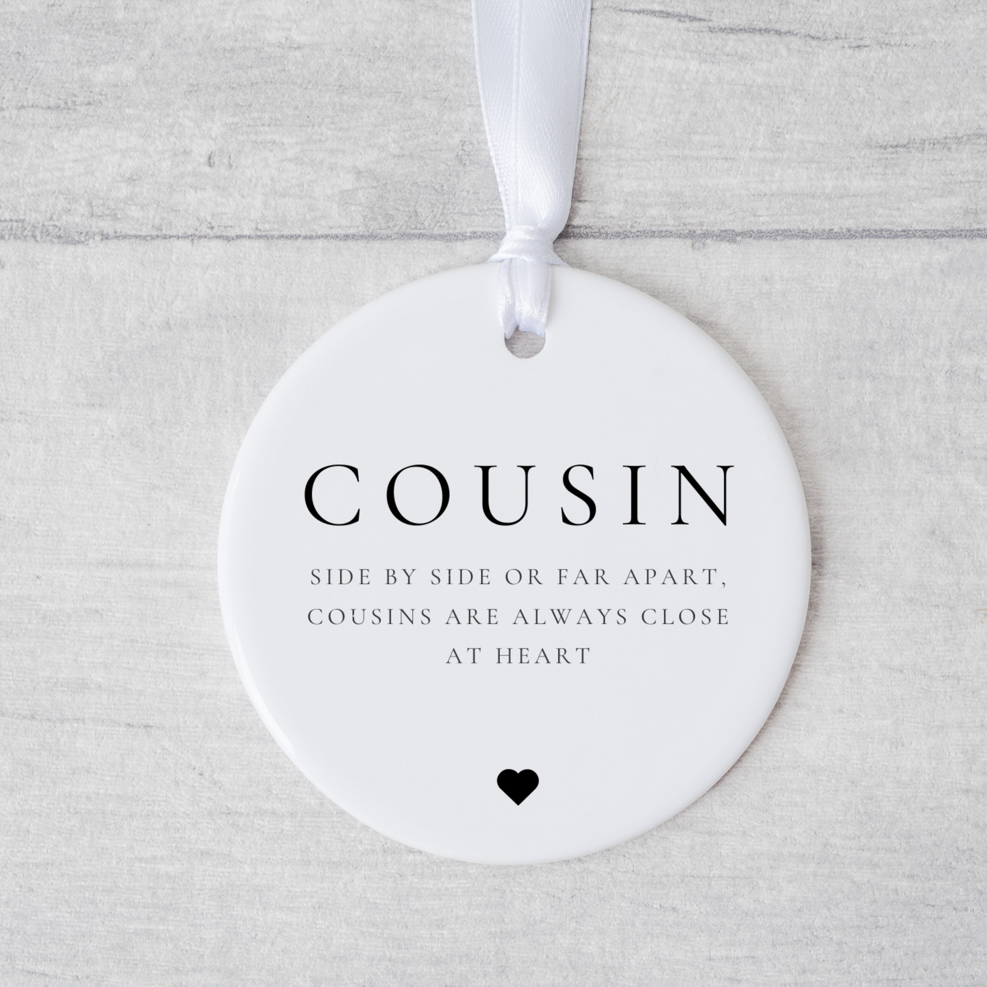 A ceramic heart-shaped cousin gift coaster with a sentimental quote, a thoughtful keepsake to celebrate the bond between cousins