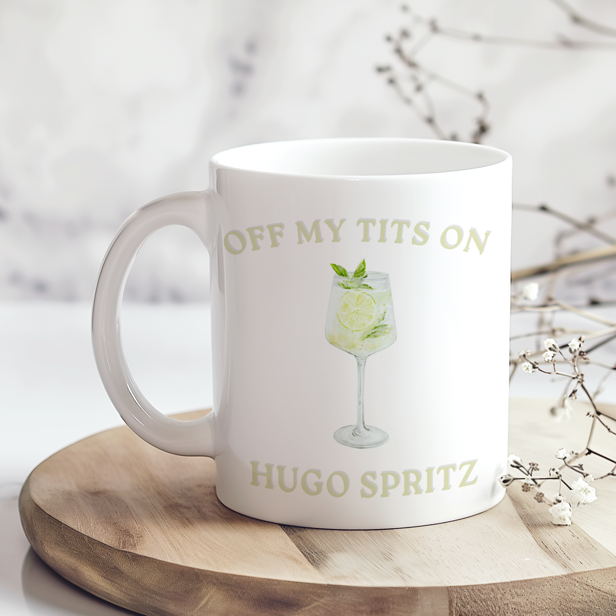 Glossy white mug with a Hugo Spritz illustration and the funny phrase Off My Tits on Hugo Spritz.