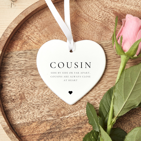 A ceramic heart-shaped cousin gift coaster with a sentimental quote, a thoughtful keepsake to celebrate the bond between cousins