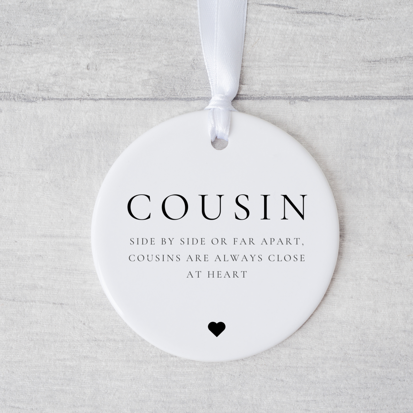 A ceramic heart-shaped cousin gift coaster with a sentimental quote, a thoughtful keepsake to celebrate the bond between cousins